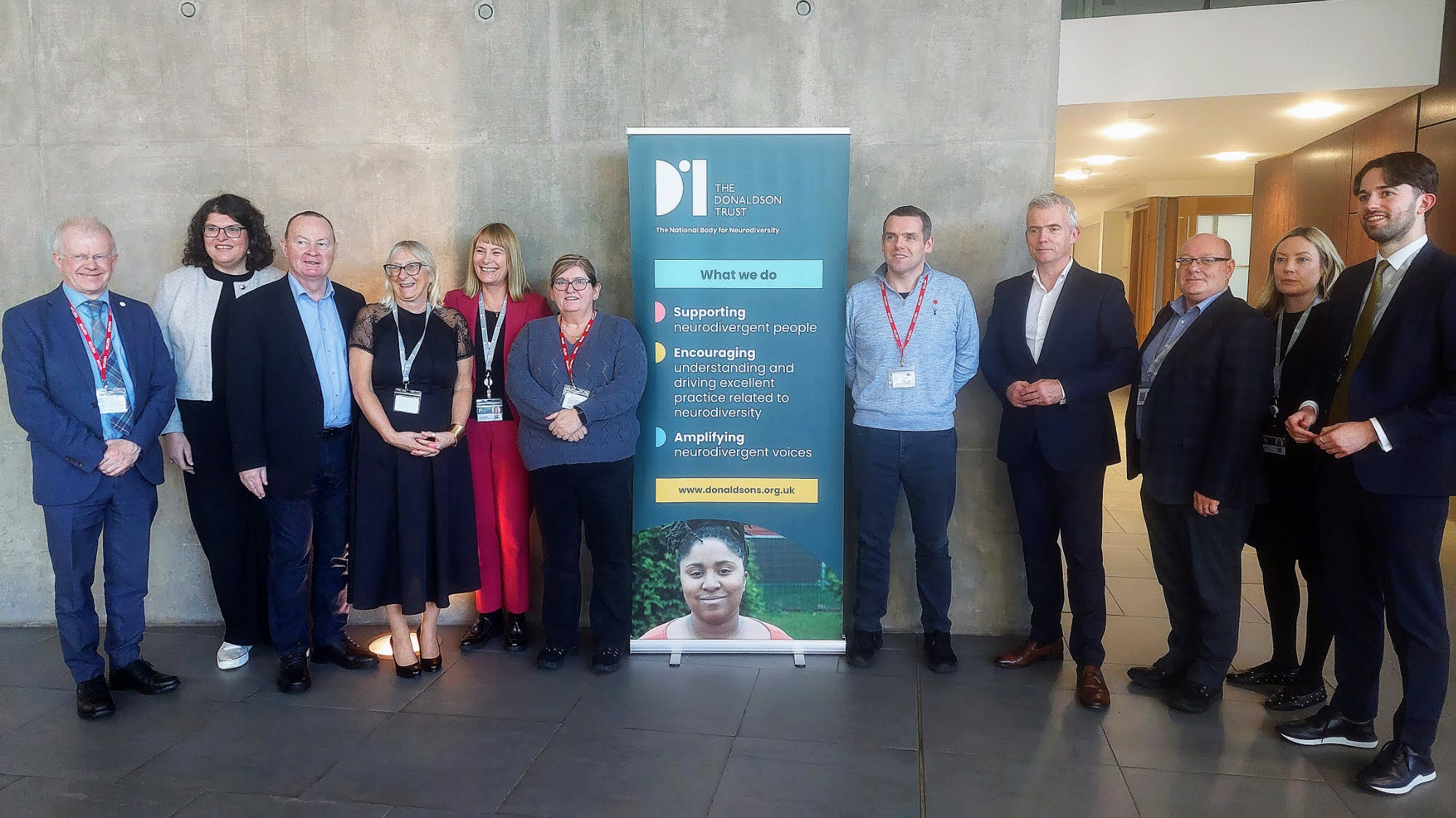 Committee members standing with teachers and staff from The Donaldson's Trust in Linlithgow.